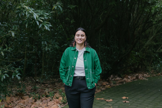 Danielle in a green jacket walking on the river path