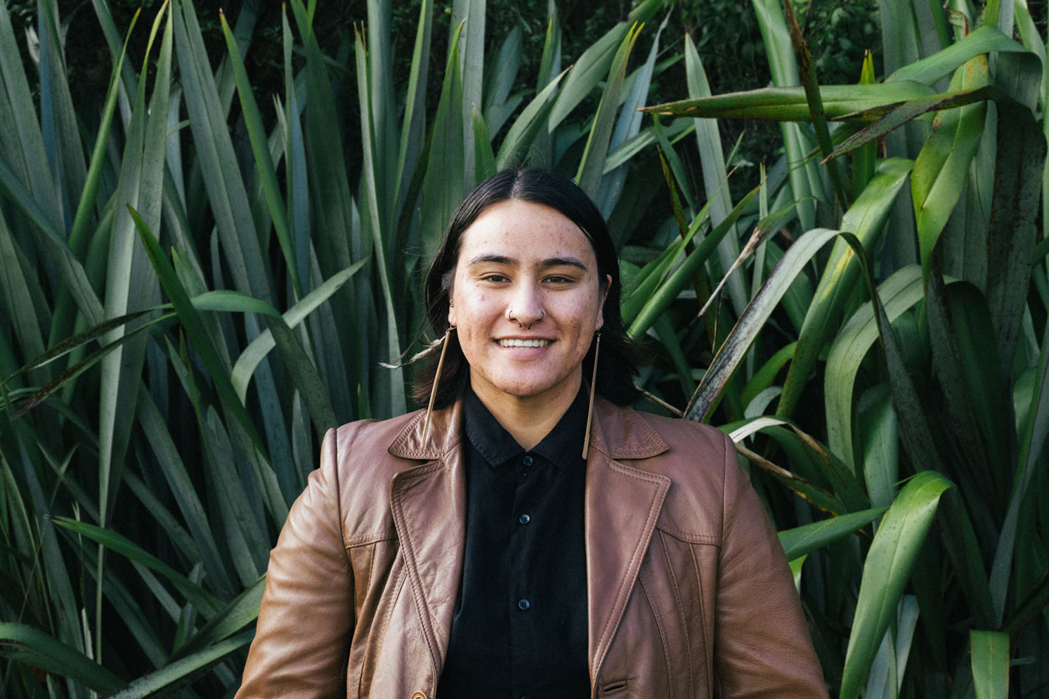 A portrait photo of Danielle Marks in front of some harakeke flax bushes